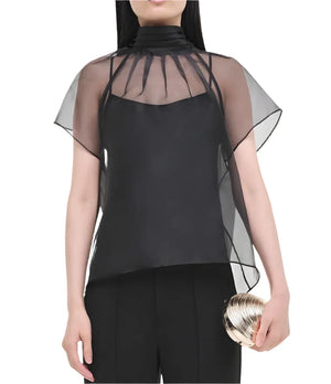 A person elegantly holding a gold clutch while wearing the Simkhai Feyre Top, which features a black sheer design with short sleeves and a high collar.