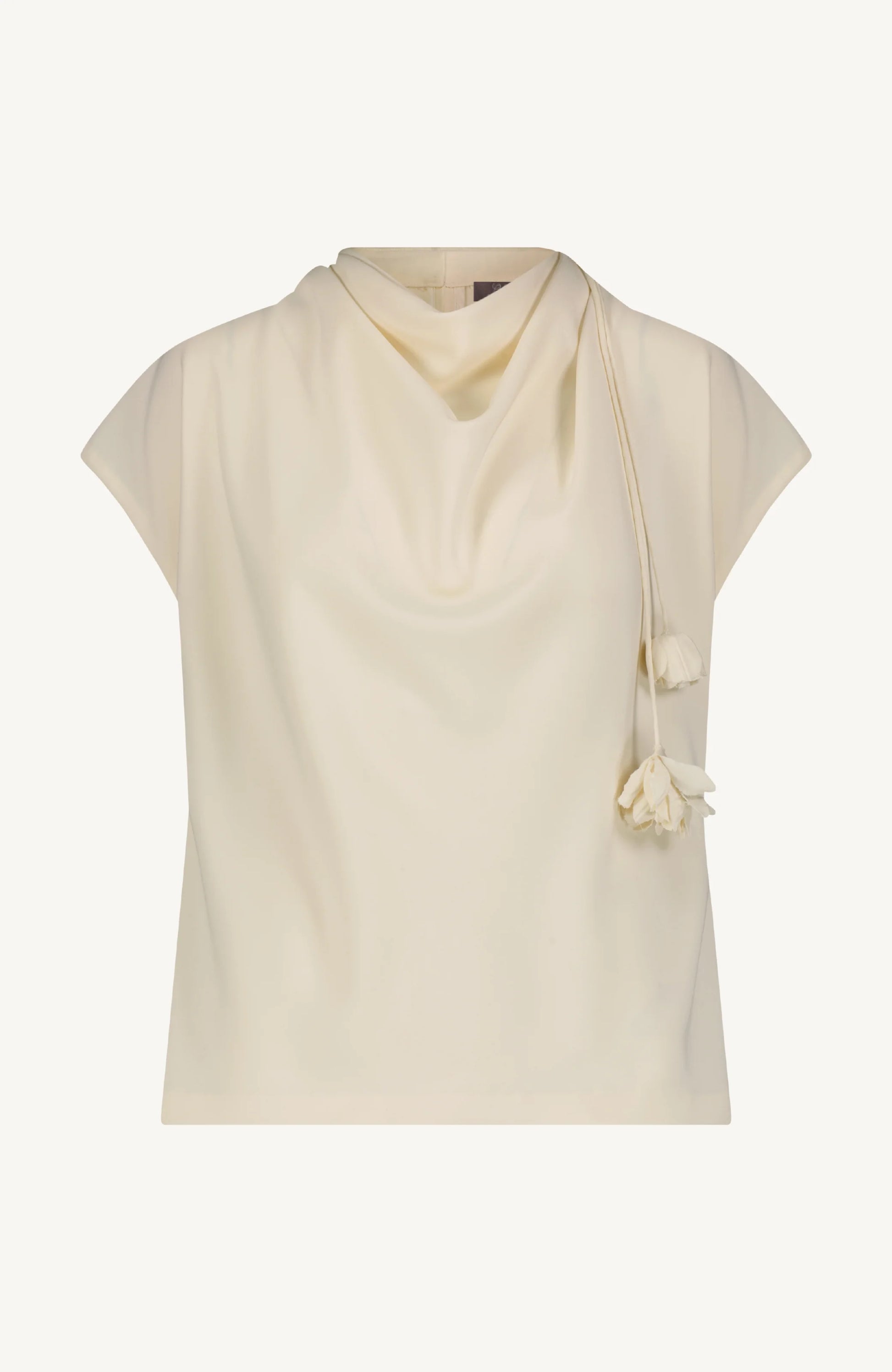 The Lela Rose Drop Flower Cowl Neck Top features a sleeveless cream crepe design with a cowl neckline and elegant drop flower accents at the neck.