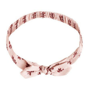 The Rylee & Cru Baby Bow Headband is a light pink fabric headband with a small floral pattern, knotted bow at the front, and soft scrunchy elastic band for comfort.