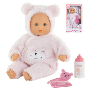The Corolle Bébé Calin - Loving Teddy Bear 12" doll wears a pink bear costume and comes with a bib, bottle, and washcloth. Its box packaging appears in the top right corner.
