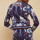 Person facing away from the camera wearing Cara Cara’s Livi Jacket, a blue, white, and brown floral jacquard knit.