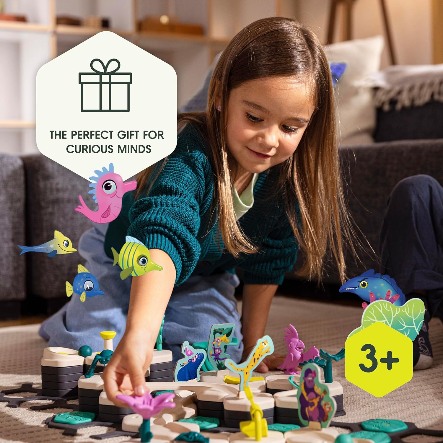 A young child enjoys the GraviTrax Junior: Ocean Starter Set by GraviTrax, a colorful STEM toy with an ocean theme. Text reads, "The perfect gift for curious minds" and "Ages 3+.