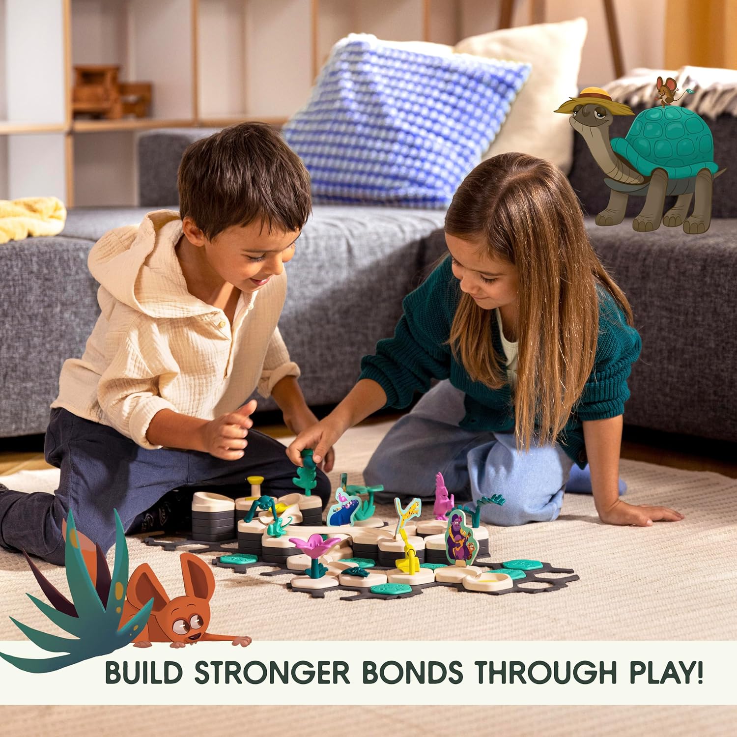 Two kids sit on the floor playing with the GraviTrax Junior: Desert Starter Set by GraviTrax, illustrated animals nearby and the phrase "Build stronger bonds through play!" shown.