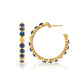 The Berry Gem Medium Hoop Earrings by Juliska Capucine De Wulf feature round blue stones and gold bead accents, showcased from side and front views on a white background—a timeless piece for any feminine jewelry collection.