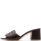 The Rupert Sanderson Laguna Heel is a black, open-toe sandal with a chunky block heel and cut-out upper strap, handmade in Italy and shown in profile.