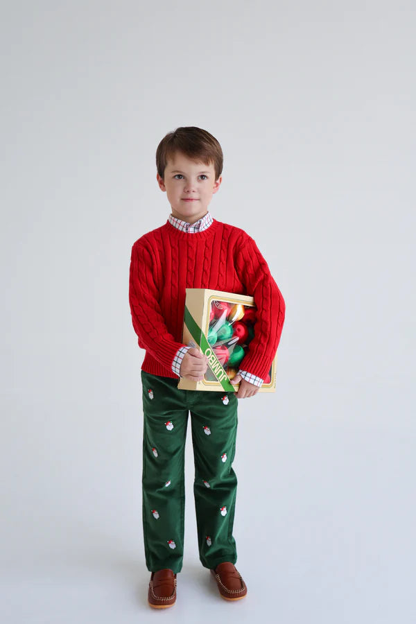 A young boy in a red sweater and The Beaufort Bonnet Company Boys' Critter Prep School Corduroy Pant holds a box of Christmas lights while standing against a plain white background.
