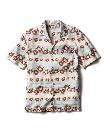 The Breeze Camp Shirt by Faherty is a short-sleeve button-up featuring light blue and white stripes, a brown floral pattern, and a chest pocket on the left side.