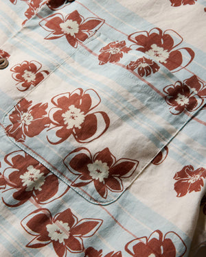 Close-up of the Faherty Breeze Camp Shirt in light blue and white plaid with brown and white floral patterns, featuring a visible chest pocket.