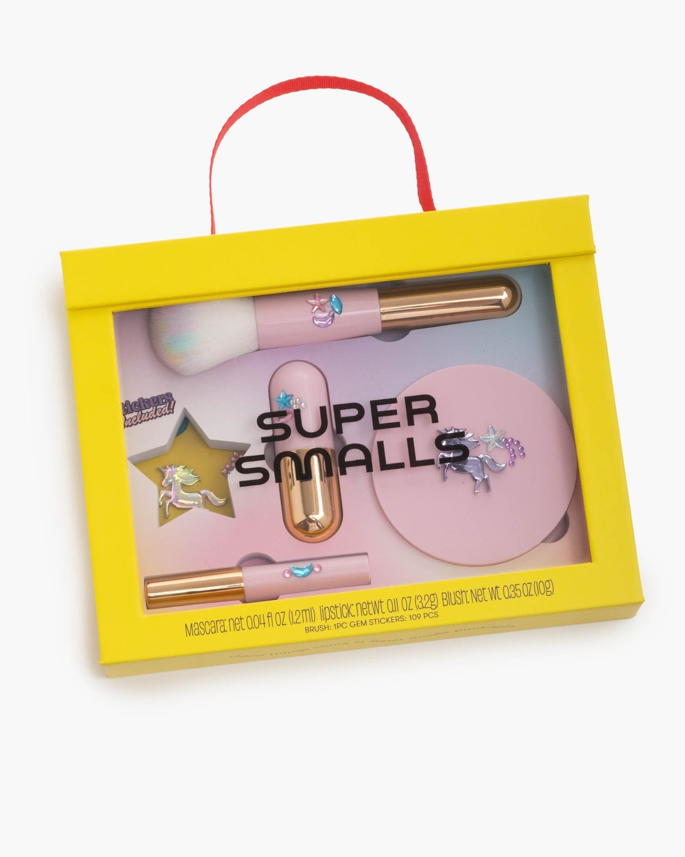 A yellow box with a red handle contains the Super Smalls Unicorn Makeup Kit, featuring unicorn-themed brushes and compacts—perfect for imaginative play or kids makeup fun.