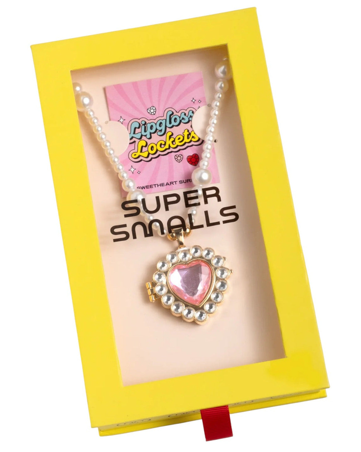 A heart-shaped gold and faux-pearl compact necklace with a pink gem, packaged in a yellow Super Smalls Sweetheart Surprise Lipgloss Locket box.