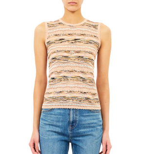 A person wears the Ulla Johnson Alisa Knit Top, a slim fit sleeveless patterned piece in pink and beige, paired with blue jeans and standing against a white background.