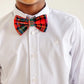 A young person wears a white dress shirt with The Beaufort Bonnet Company’s Baylor Bowtie in Paces Mill Plaid, a pre-tied adjustable bow tie with a subtle embroidered logo on the chest, smiling.
