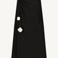 The Drop Flower Ruched Skirt by Lela Rose is a black midi A-line silhouette crafted from fluid crepe, featuring a ruched waist with two white drop flower embellishments.