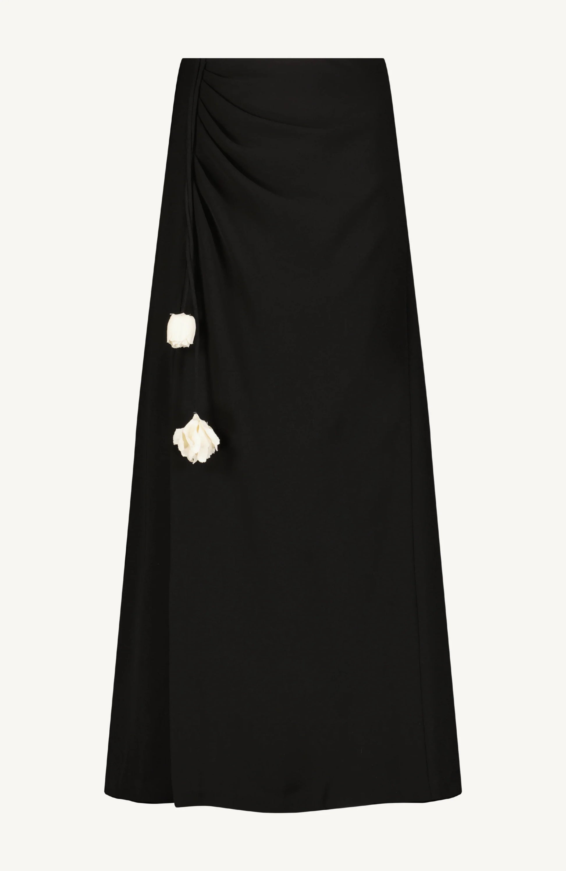 The Drop Flower Ruched Skirt by Lela Rose is a black midi A-line silhouette crafted from fluid crepe, featuring a ruched waist with two white drop flower embellishments.