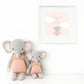 Two Eloise the Elephant - Little 13" dolls by Cuddle + Kind in pink outfits sit below a framed "Dream Big" elephant art on a soft pink, cloud-filled background—a perfect birthday gift and adorable keepsake.