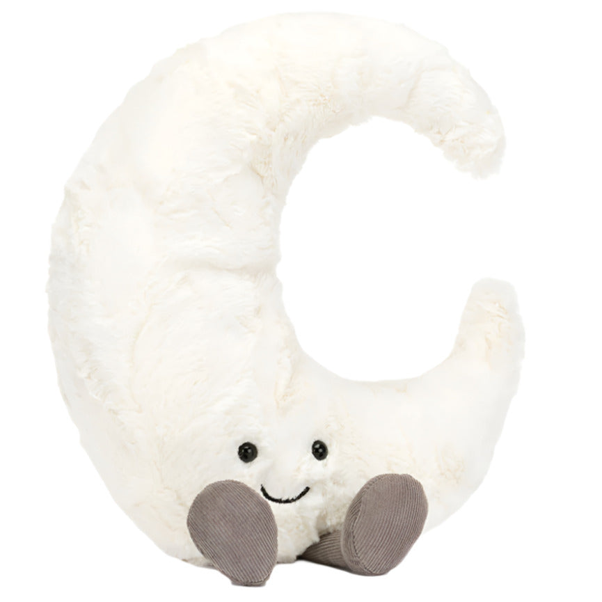 The Jellycat Amuseables Moon plush toy, by Jellycat, is designed in the shape of a crescent moon with a cheerful smiling face and two tiny gray feet, set against a white background.