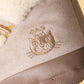 Close-up of the Amuseables Perta Snow Boot by Jellycat, featuring a stitched cat face, bee detail, fuzzy white lining, and visible stitching—ideal for Christmas décor.