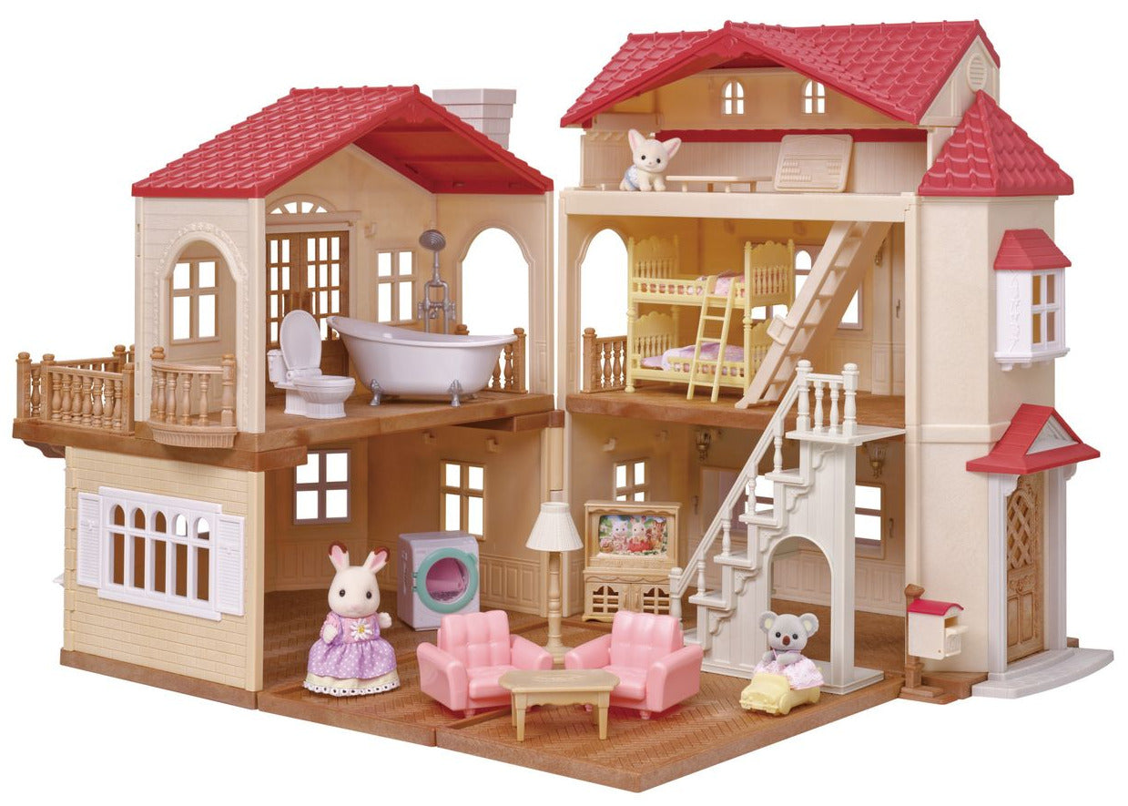 Three animal figurines in a detailed, open Calico Critters Red Roof Country Home Gift Set dollhouse playset with furniture, including a bathtub, sofa, chairs, beds, lamps, and stairs, all under signature red roofs.