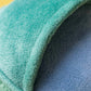 Close-up of a soft, teal and blue fabric tunnel with a textured surface, echoing the playful design of the Amuseables Watering Can by Jellycat. Likely part of a pet bed or play structure.