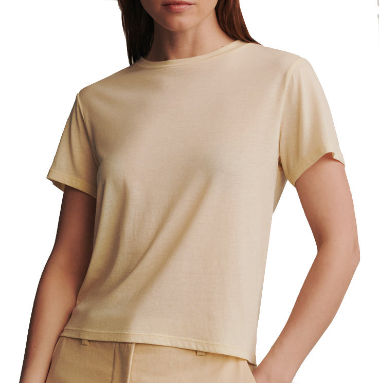 A woman wearing a plain beige TWP His Tee, cropped to show only from her neck to her waist.