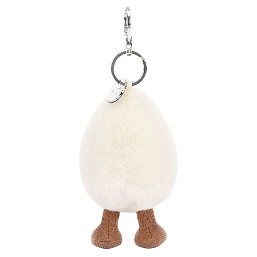 The Amuseables Happy Boiled Egg Bag Charm by Jellycat features a fluffy, egg-shaped design with brown knitted legs and a silver keyring on top.