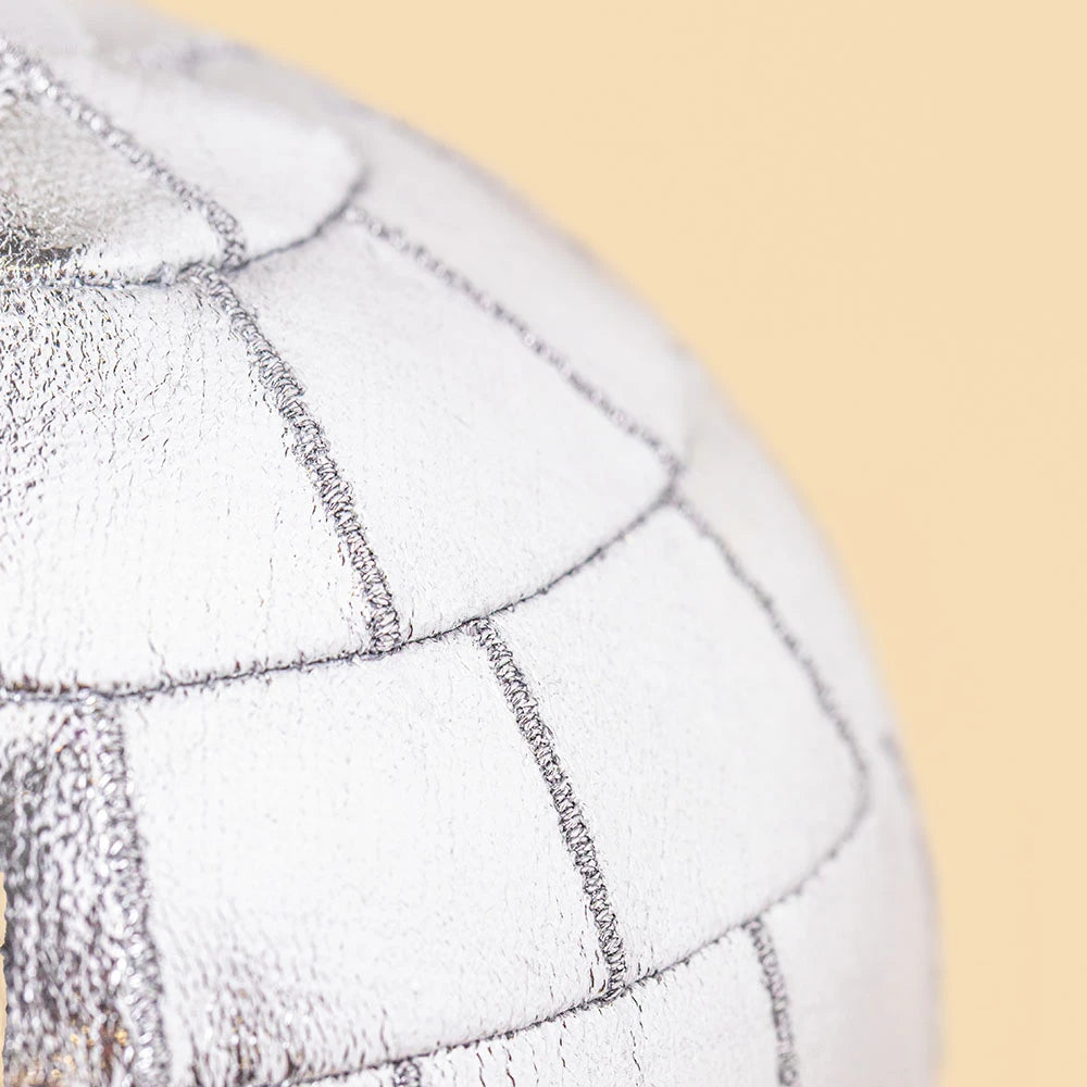 Close-up of a silver Jellycat Amuseables Disco Ball Bag Charm with a stitched grid pattern.