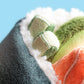 Close-up of Jellycat's Amuseables Coneroi Temaki plush, designed to resemble a sushi roll with soft green, orange, and white fabric—ideal for party planners or event coordinators seeking adorable sushi-themed decor.