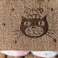 Close-up of the brown textured fabric on Jellycat’s Amuseables S’mores plush, showing embroidered details and playful dot patterns.