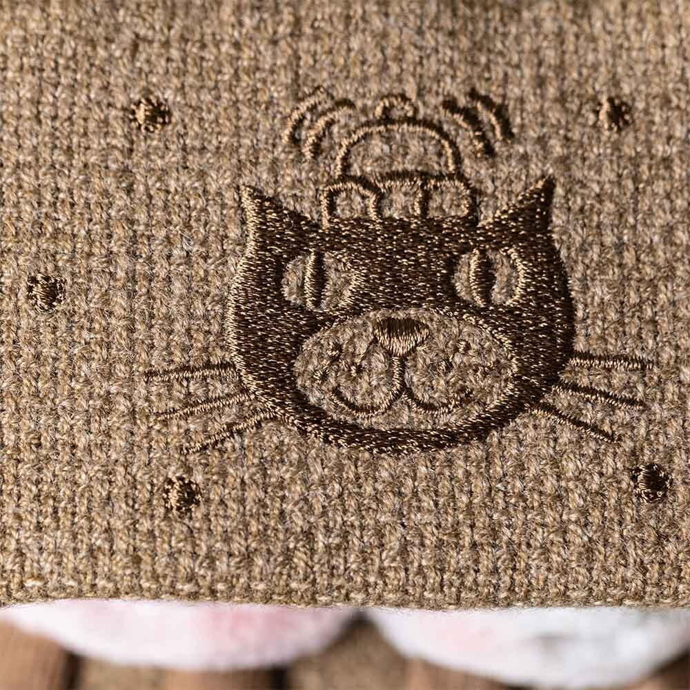 Close-up of the brown textured fabric on Jellycat’s Amuseables S’mores plush, showing embroidered details and playful dot patterns.