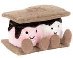 The Jellycat Amuseables S'mores is a plush shaped like a s'more, with two smiling marshmallows featuring pink cheeks, chocolate, and graham cracker pieces on the top and bottom.
