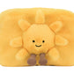 The Jellycat Amuseables Sun Pouch is a rectangular yellow fur pouch featuring a smiling sun with soft rays, a cheerful face, and dangling legs on the front.