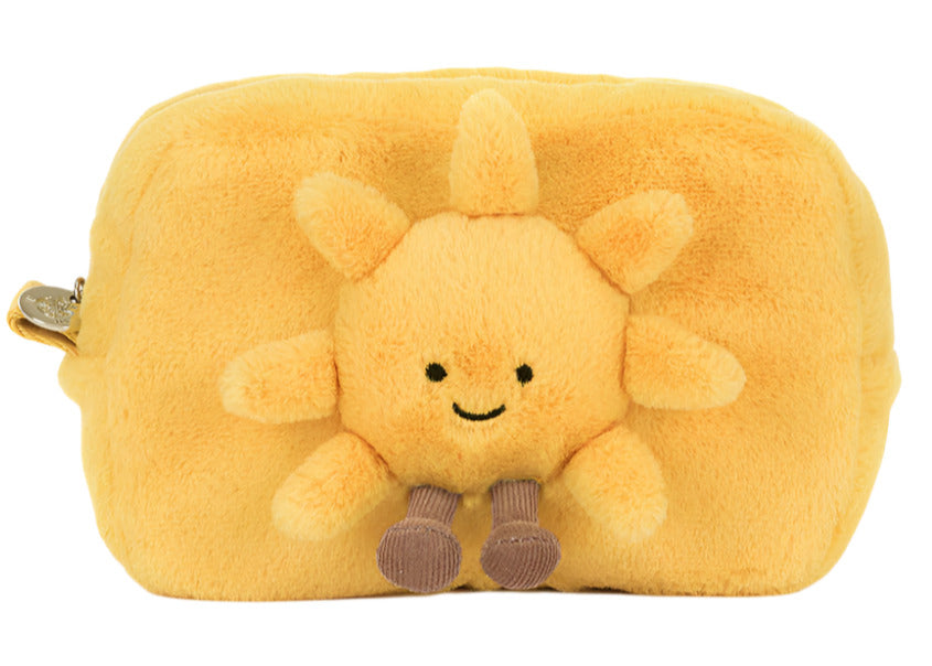 The Jellycat Amuseables Sun Pouch is a rectangular yellow fur pouch featuring a smiling sun with soft rays, a cheerful face, and dangling legs on the front.