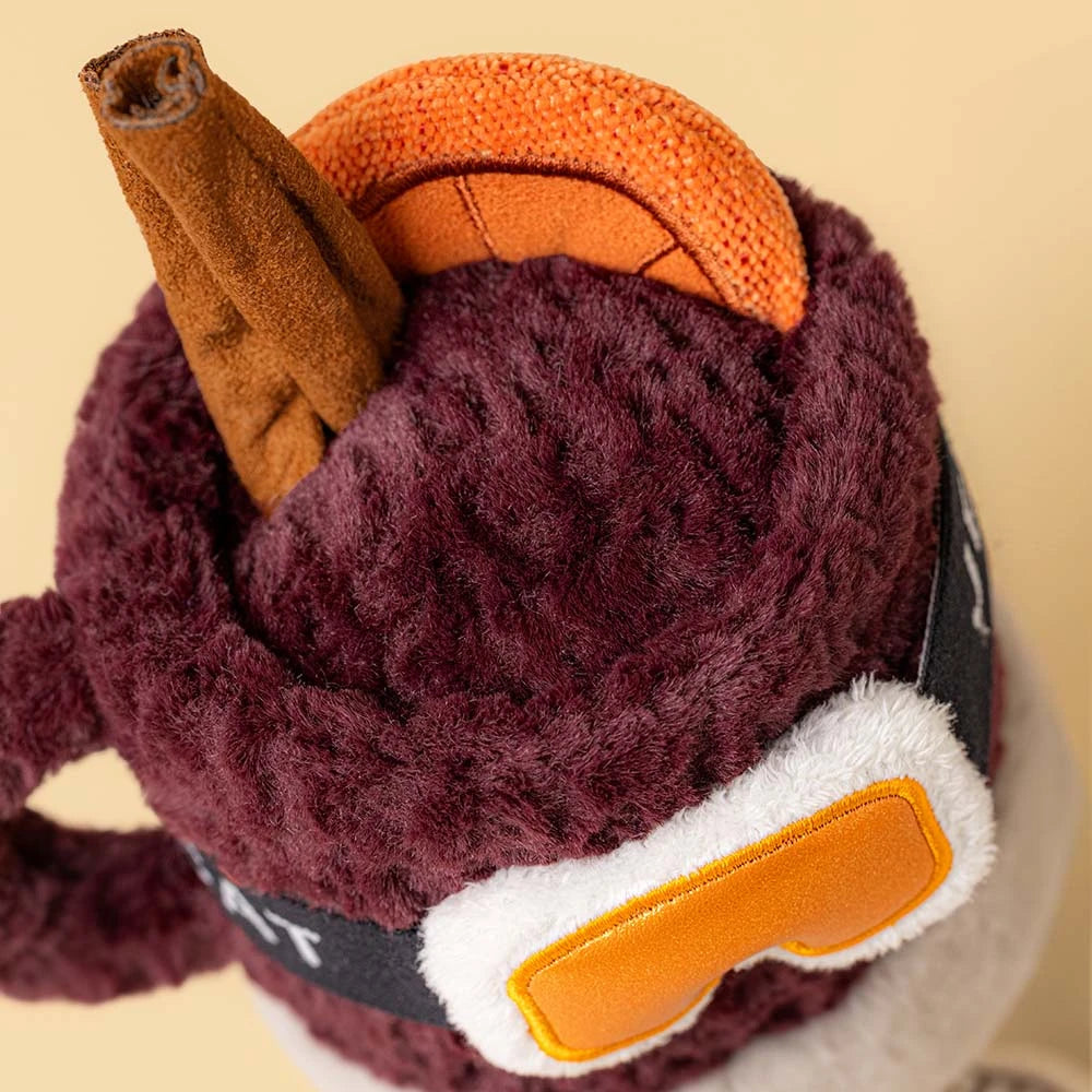 Jellycat Amuseables Mullover Spiced Drink plush toy with a cinnamon stick, orange slice topper, and stitched goggles on the front.