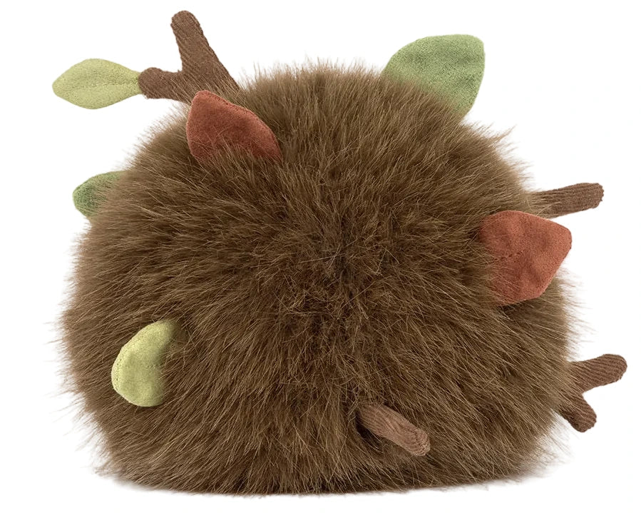 The Jellycat Amuseables Mulshi Woodland Floor is a round, brown, fluffy plush with green and brown felt leaves and branches, resembling a whimsical forest creature.
