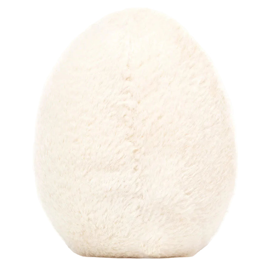 A soft, oval-shaped white plush toy, resembling a fuzzy egg, is shown standing upright against a plain white background. This charming item is the Jellycat Amuseables Boiled Egg Happy plush.