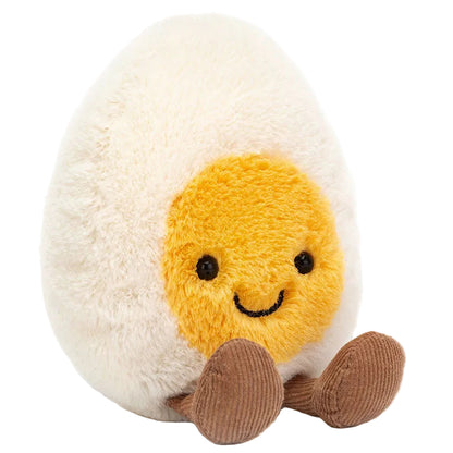 A soft toy from Jellycat, the Amuseables Boiled Egg Happy features a cheerful face, yellow yolk center, and brown feet, adding whimsical charm to any collection.