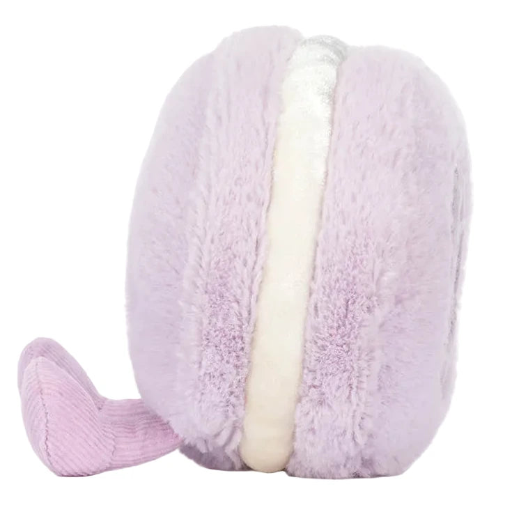 The Jellycat Amuseables May Macaron - Lavender is a macaron-shaped plush with light purple sides, white filling, and a small purple tail, shown against a white background.