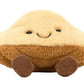 The Jellycat Amuseables Margaux Madeleine plush toy features a smiling face and small brown feet in a cute madeleine shape, displayed against a white background.