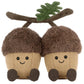 The Jellycat Amuseables Ort & Tum Acorns plush toys feature brown fuzzy caps, black button eyes, stitched smiles, and a green fabric leaf on a brown stem.