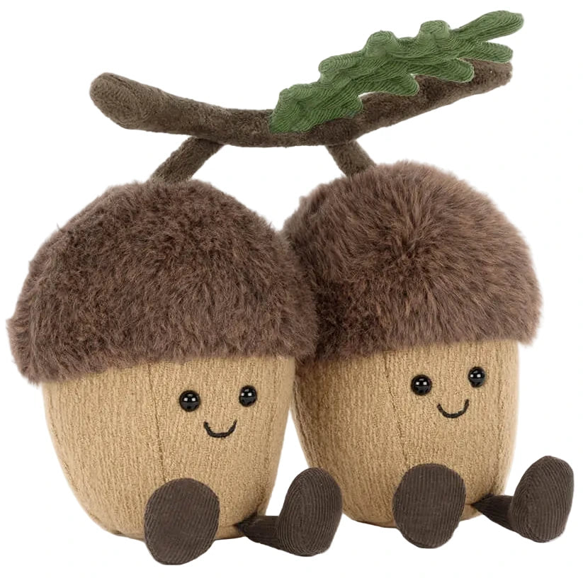 Two Jellycat Amuseables Ort & Tum Acorns plush toys with brown fuzzy caps, smiles, and dangling legs, joined by a soft oak leaf and branch on top.