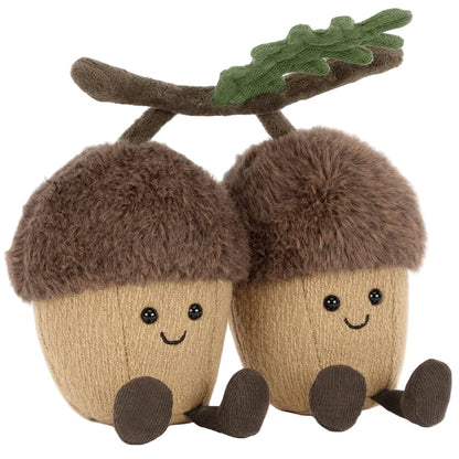 Two Jellycat Amuseables Ort & Tum Acorns plush toys with brown fuzzy caps, smiles, and dangling legs, joined by a soft oak leaf and branch on top.