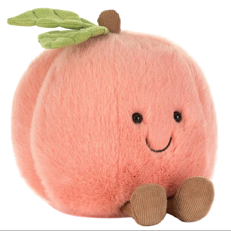 The Jellycat Amuseables Peach is a plush toy shaped like a peach, featuring a smiling face, brown feet, and green leaves on top.