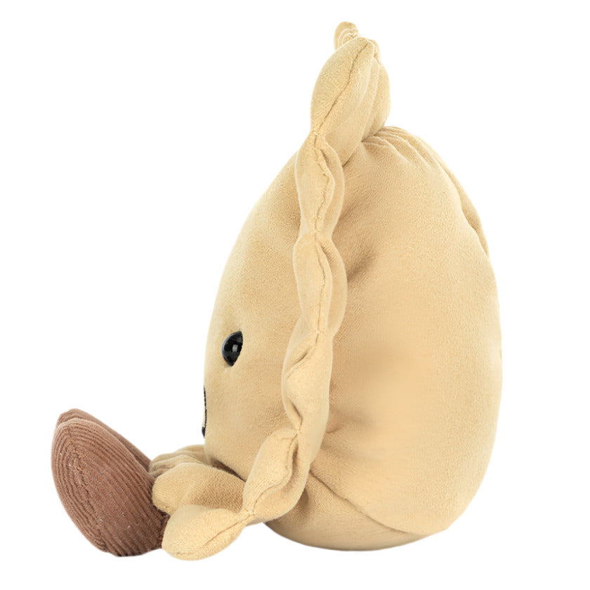 Side view of Jellycat's Amuseables Ravioli, a round beige plush toy resembling a dumpling, featuring a cute face and brown base—ideal for adding charm to any kitchen shelf.
