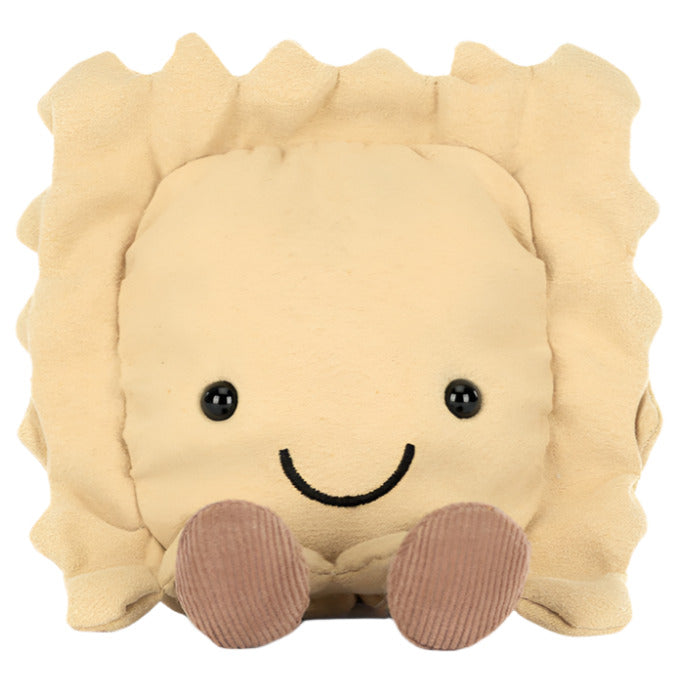 Introducing Jellycat's Amuseables Ravioli, a plush joy with a smiling face and small brown feet. Ideal for charming any kitchen shelf, this soft toy adds whimsical flair wherever it rests.