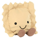 The Jellycat Amuseables Ravioli is a charming plush toy shaped like beige pasta, featuring a smiling face, stitched eyes, and brown textured feet. It's the perfect addition to any kitchen shelf with its delightful presence.