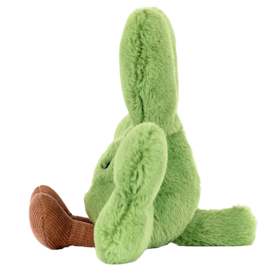 The Jellycat Amuseables Siofra Shamrock plush sits upright in profile against a white background, featuring a green body, long ears, and a brown snout and tail.