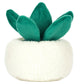 The Jellycat Amuseables Skull Planter is a plush toy shaped like a green succulent with thick leaves, set in a round, white, fuzzy skull planter for a playful touch.
