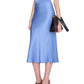 A person wearing the Bar Silk Skirt by Anine Bing, styled as a sleeveless light blue satin midi dress, paired with black heeled sandals and holding a black clutch bag against a white background.