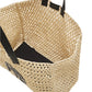The Anine Bing Large Rio Tote is a woven seagrass bag featuring black handles and a black rectangular inner base, shown from above at an angle.