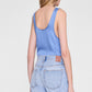 A person wearing the Anine Bing Lea Top in light blue, styled with light blue high-waisted jeans, seen from the back against a plain background.